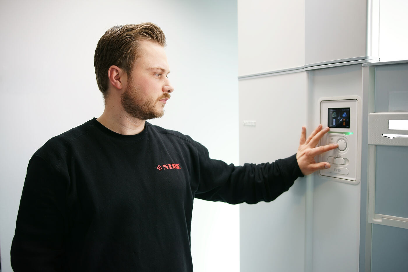 NIBE engineer checking a heat pump control panel